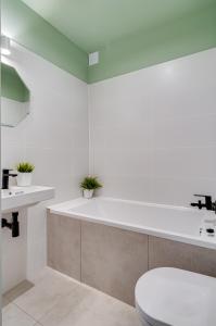 a white bathroom with a toilet and a sink at COMFISTAY Plac Piłsudskiego 8 - Rynek i Amfiteatr in Opole