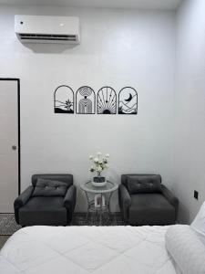 1 dormitorio con 2 sillas, 1 cama y 1 mesa en Rumah Petak Melor, en Gua Sai