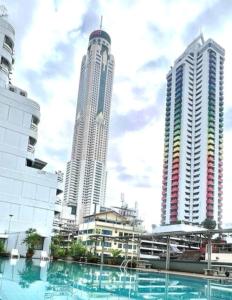 two tall buildings in a city with a swimming pool at ATVR Juldis Tower Pratunam in Bangkok