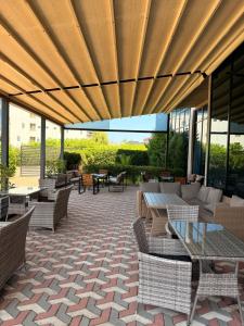 patio con tavoli e sedie sotto un ombrellone in legno di Comfortium a Kobuleti