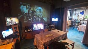 a living room with a table and televisions in a room at Pohang Poderosa Blue Guesthouse in Pohang