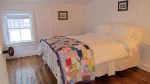 a bedroom with a bed with a quilt on it at The Old Salt Box Co. - Aunt Glady's in Fogo