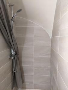 a shower with a shower curtain in a bathroom at Micro-ferme agroécologique in Joyeuse