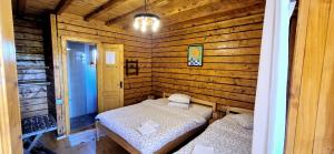 a small room with two beds in a log cabin at Casa Moața La Vama Veche in Vama Veche