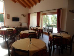 a restaurant with tables and chairs and a large window at Agriturismo Gradec in Aurisina