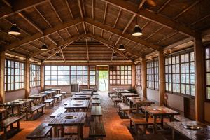 een grote kamer met houten tafels en ramen bij 神石高原ティアガルテン 