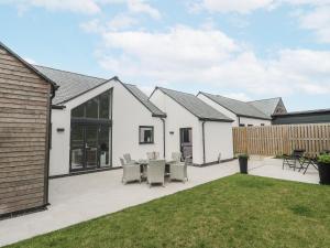 a house with a patio with a table and chairs at Kerrek Lodge in Falmouth