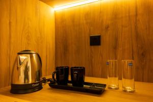 a coffee maker and two glasses on a wooden table at Casazia in Yercaud