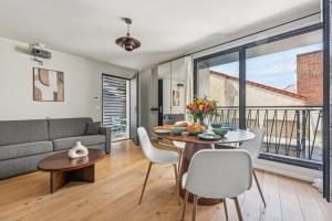 una sala de estar con una mesa y un sofá en City Center l 15min from Eiffel Tower by Car, en Boulogne-Billancourt