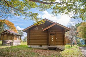 een blokhut in een park met bomen bij 神石高原ティアガルテン 