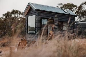 a woman standing in the doorway of a tiny house at Tiny Elsie in Kalkite