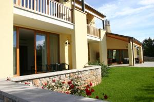 a house with a retaining wall and a garden at Agriturismo Gradec in Aurisina