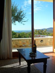 a table with two wine glasses on it with a window at Agriturismo Gradec in Aurisina