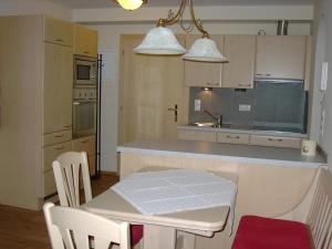 cocina con mesa, sillas y mesa blancas en Anna's Appartements, en Pertisau