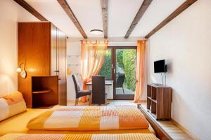 a bedroom with a bed and a desk with a television at Gästehaus Gaby in Bad Bellingen