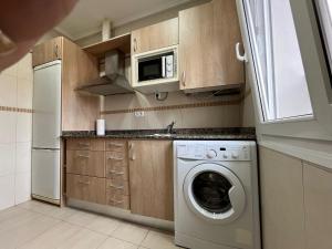 a kitchen with a washing machine and a microwave at Estudios Blanmart in Santander +12 photos