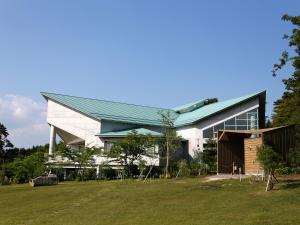 een groot wit gebouw met een groen dak bij 神石高原ティアガルテン  +41 foto's