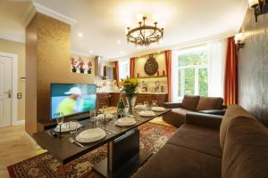 Una sala de estar con un sofá y un televisor. en BridgeStoneLuxApart Free Parking, en Riga