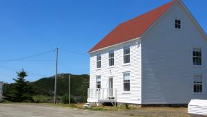 a large white house with a red roof at The Old Salt Box Co. - Evelyn's Place in Herring Neck