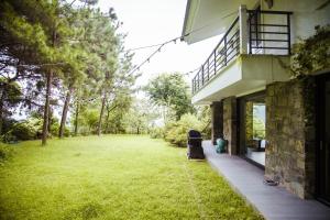 une maison avec une cour herbeuse à côté d'un bâtiment dans l'établissement YenYen Villa - 2000m2 villa in Tam Dao Golf Course, à Làng Hạ