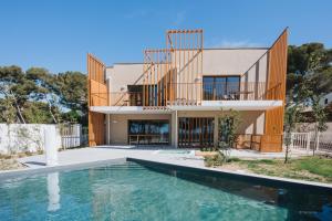 ein Haus mit einem Swimmingpool vor dem Haus in der Unterkunft La Corniche Bleue in Sausset-les-Pins