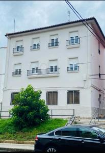 a black car parked in front of a white building at Estudios Blanmart in Santander