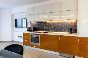 a kitchen with wooden cabinets and a sink at Limani Comfort Rooms in Thessaloniki