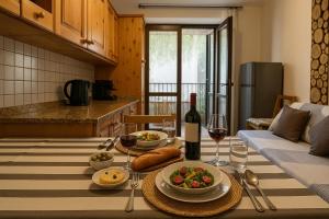 a table with a bowl of food and a bottle of wine at Dimora i Laghi Tra Como, Lecco e Bellagio in Erba