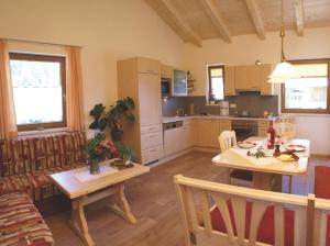 kuchnia i salon ze stołem i kanapą w obiekcie Anna's Appartements w mieście Pertisau