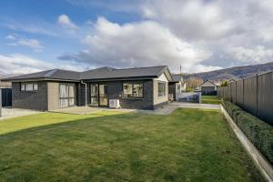 a house with a large lawn in front of it at Sunrise Hideaway - Cromwell Holiday Home in Cromwell
