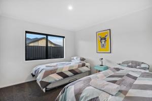 two beds in a room with a window at Sunrise Hideaway - Cromwell Holiday Home in Cromwell