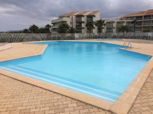 Una gran piscina azul frente a un edificio en Résidence Les Goélettes, en Saint Cyprien Plage 9 fotos más