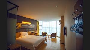 a hotel room with a bed and a desk and a bedroom at IU Hotel Shangqiu Kaixuan Road Zhonghuan Square Branch in Shangqiu +232 photos