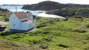 a house on a hill next to the ocean at The Old Salt Box Co. - Daisy's Place in Herring Neck