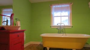 a green bathroom with a tub and a window at The Old Salt Box Co. - Daisy's Place in Herring Neck