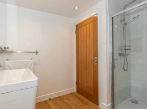 a bathroom with a shower and a sink and a glass door at Sea Breeze in Poole +17 photos