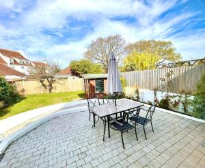 a table and chairs with an umbrella on a patio at Sea Breeze in Poole