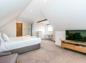 a bedroom with a large bed and a flat screen tv at Sea Breeze in Poole