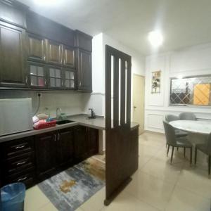 a kitchen with a table and a dining room at Express Room KBCC in Kota Bharu