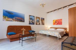 um quarto com uma cama, um sofá e uma mesa em Apartments Rudjer em Dubrovnik