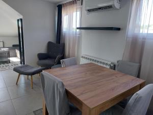 Un comedor con mesa y sillas de madera. en Dedinje Top, en Belgrado