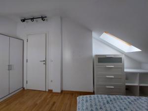 Un dormitorio con una cama y una claraboya y un armario. en Dedinje Top, en Belgrado