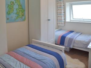a small room with two beds and a window at Lavender Cottage in Buckfastleigh +4 photos