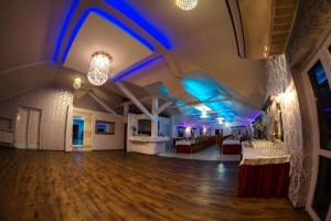 Willa Imperium في أوستروفيتس شفينتوكجسكي: غرفة كبيرة مع أرضية خشبية وإضاءة زرقاء