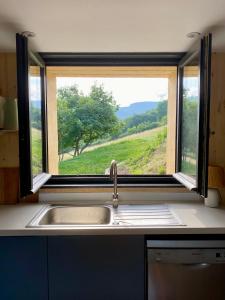a kitchen sink with a window with a view of a field at Clos Sauvage in Leynes