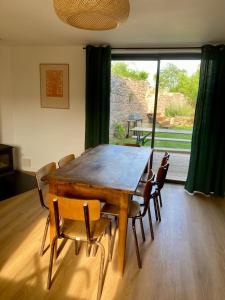 a dining room table with chairs and a large window at Clos Sauvage in Leynes +13 photos