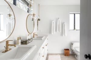 a bathroom with two sinks and a mirror at Silver Triangle Oasis with Verdant Backyard in Los Angeles +21 photos