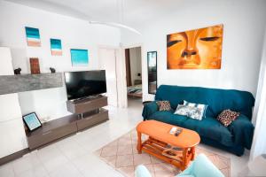 a living room with a blue couch and a tv at La casa del mar Nuimna in Peñíscola