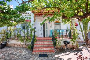 a white house with a staircase leading to the front door at La casa del mar Nuimna in Peñíscola