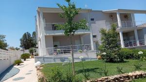 a white apartment building with a tree in the yard at L'ulivo D'oro in Laterza